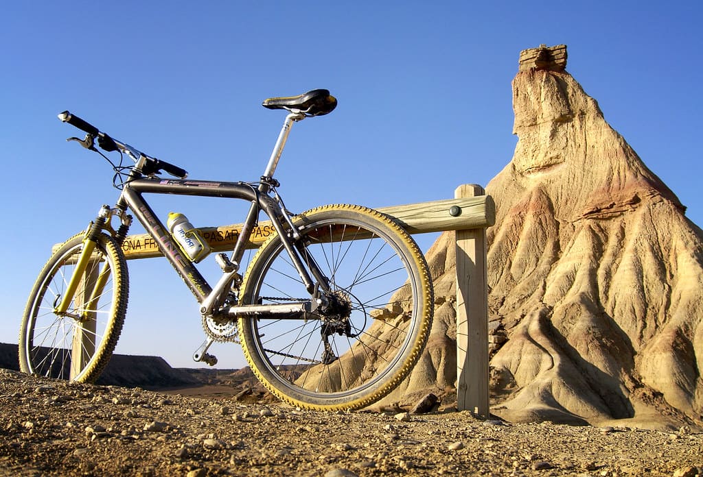 Bici apoyada en una valla de madera en las Bardenas Realesdurante una ruta por el desierto.