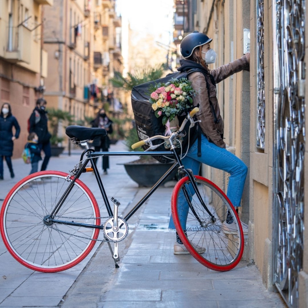 Florster delivery woman with her urban bike equipped with Tannus Tires color Volcano Red.