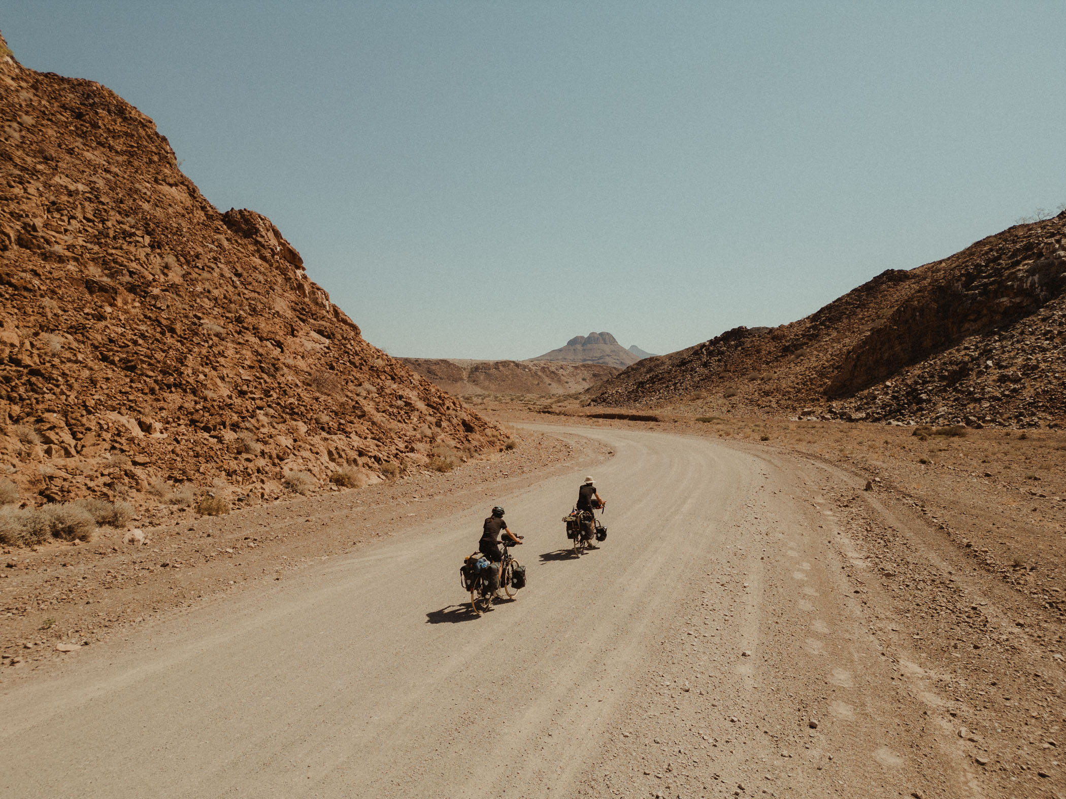 Karabana project riders pedaling through the Namib Desert on their Tannus Tires equipped touring bikes.