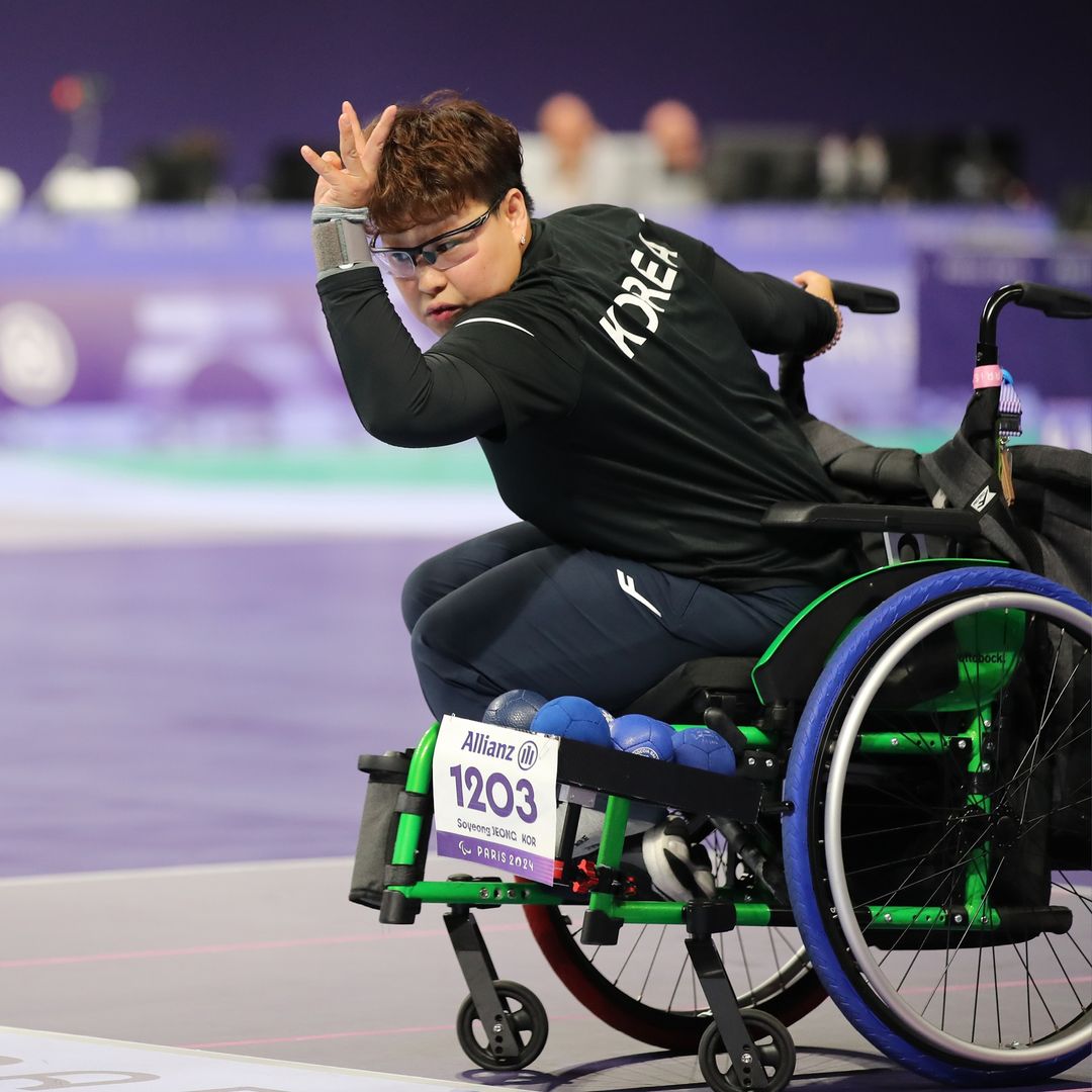 L'athlète Jung So-Young participe à une compétition de boccia avec le Tannus dans son fauteuil roulant bleu.