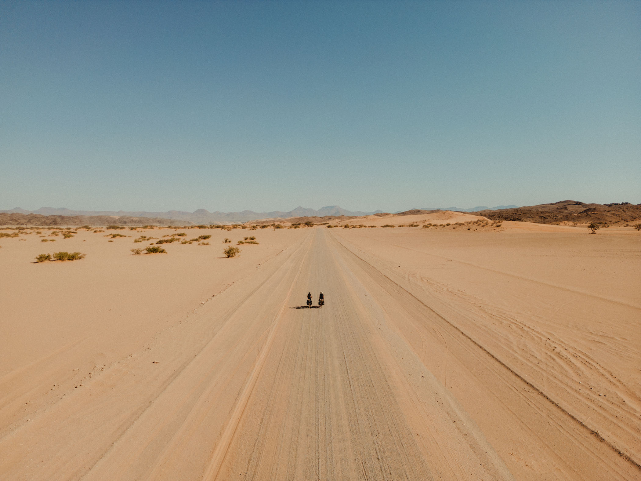 David et Elena de Karaban traversant à vélo l'immensité du désert sur une route sans fin.