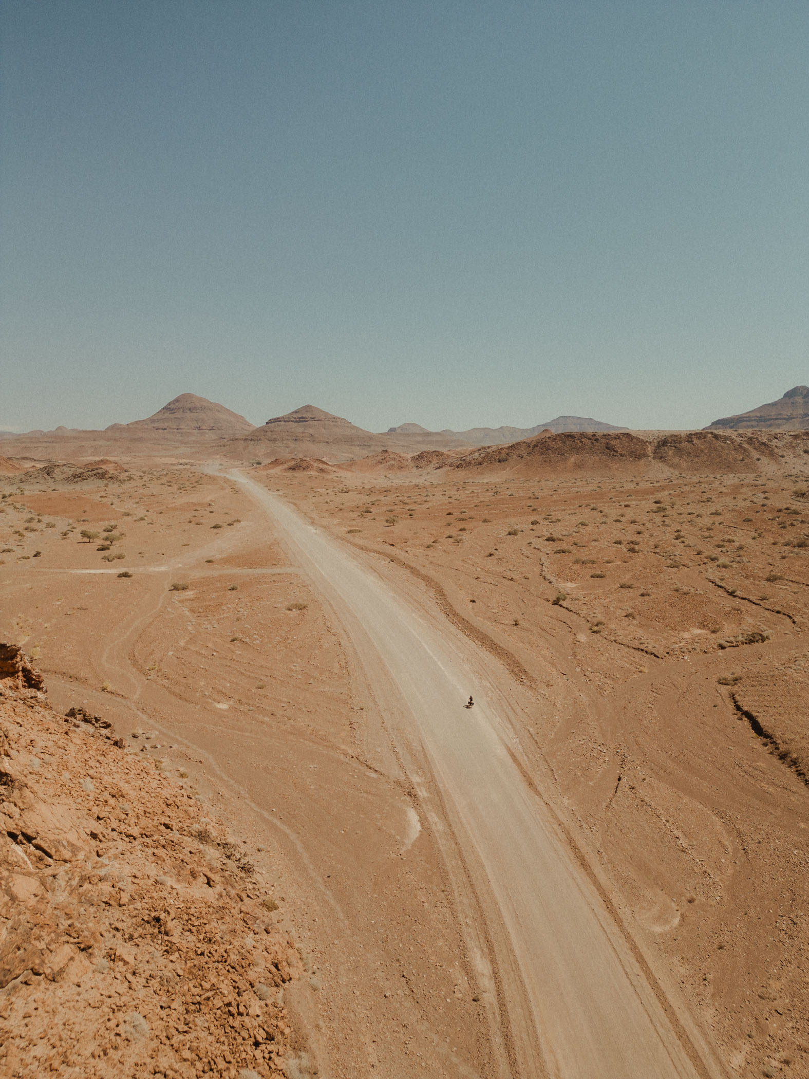 Plano muy lejano de Karaban pedaleando en medio del desierto