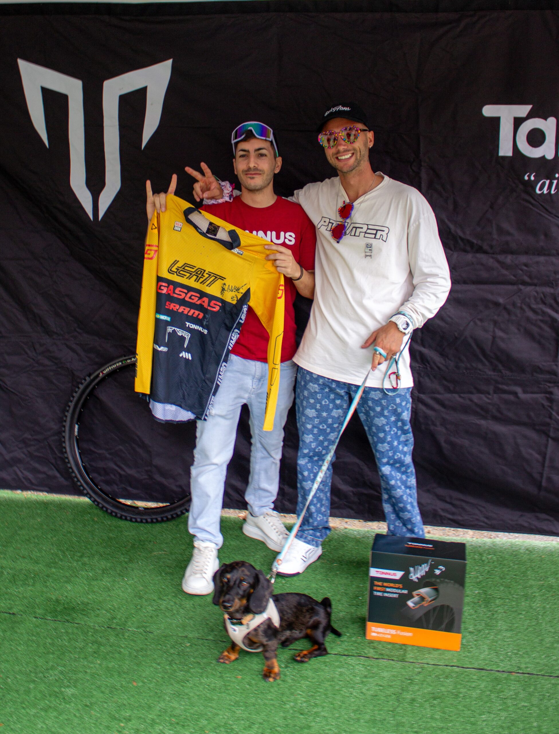 Ale Marin y un miembro del equipo de Tannus sujetando al equipación firmada el stand de Tannus en Sea Otter 2024