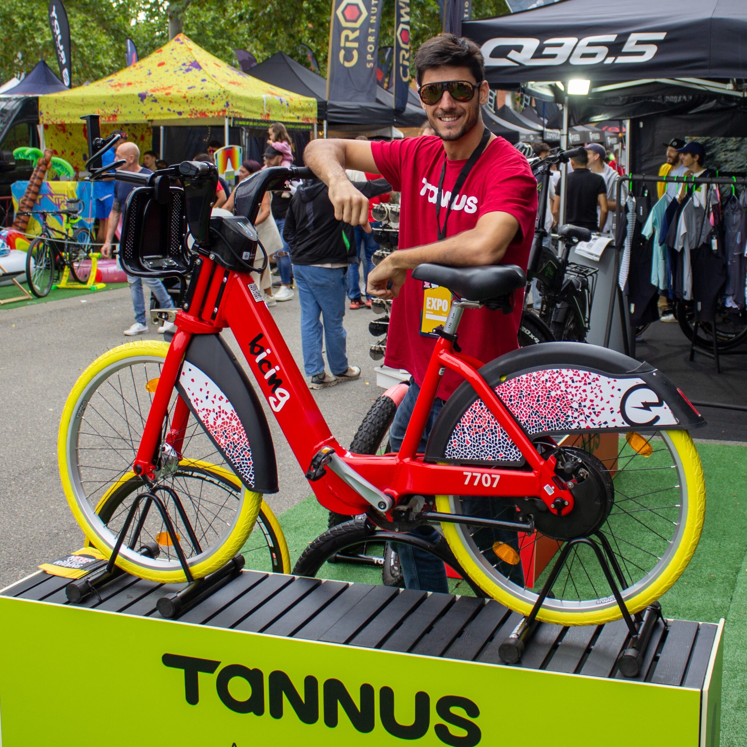 Tannus-Stand auf der Sea Otter 2024: Tannus-Teammitglied mit dem Bicing BCN-Rad, das mit Tannus-Reifen ausgestattet ist.