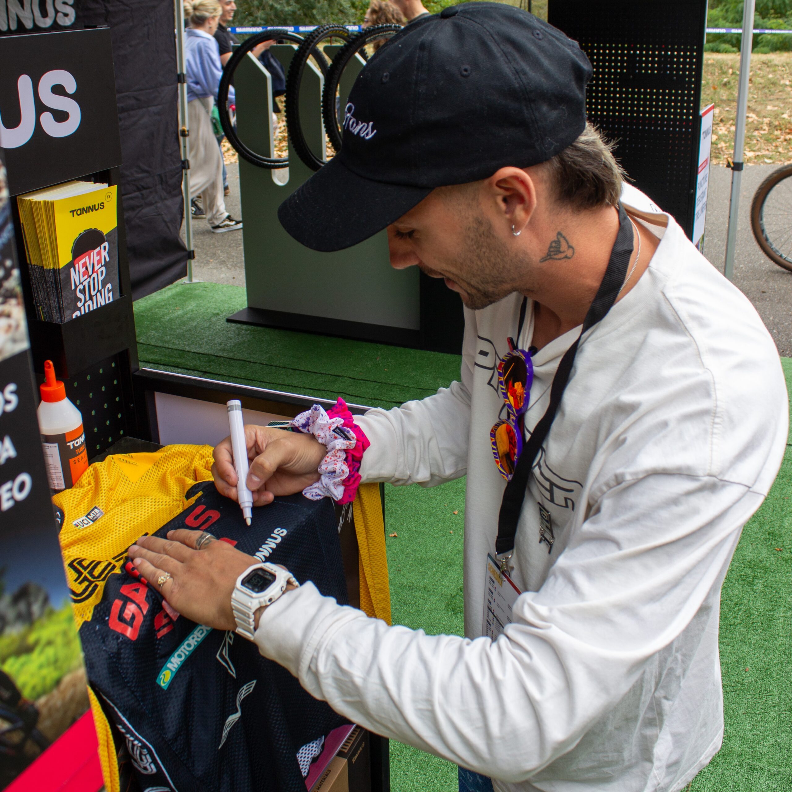 Alex Marin bij de Tannus-stand op Sea Otter 2024 die zijn WK-kit signeert.