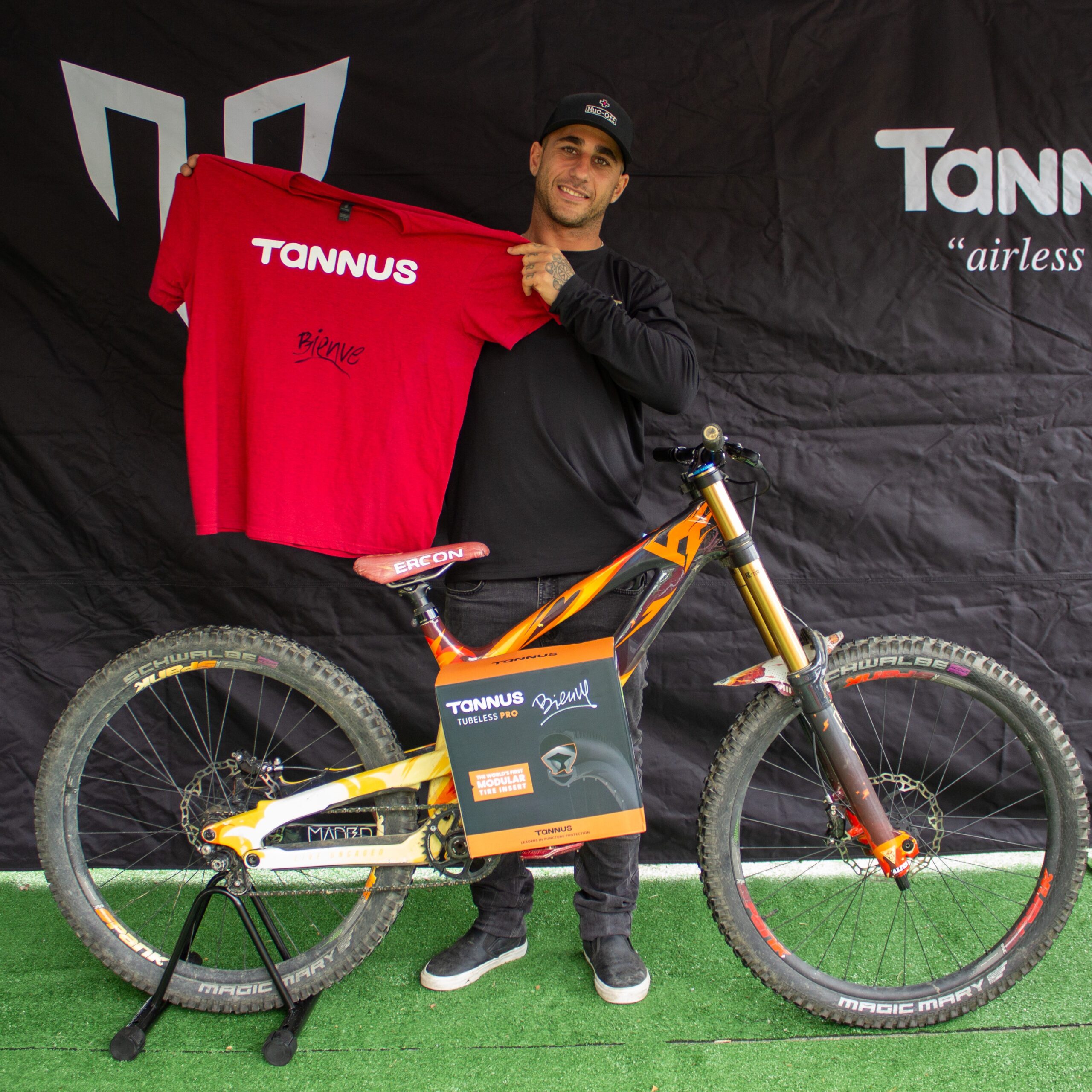 Welcome Aguado at the Tannus stand at Sea Otter 2024 with a Tannus Tubeless PRO on the bike pedal, holding a signed Tannus T-shirt.