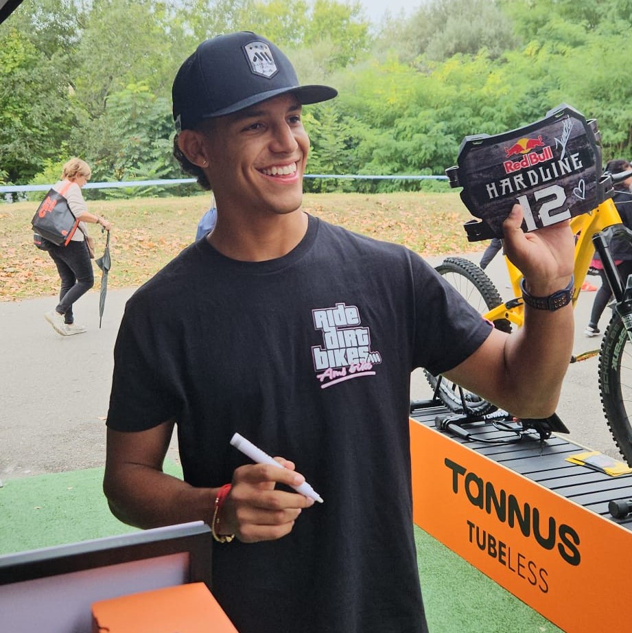 Juanfer Velez bij de Tannus-stand op Sea Otter 2024 met de Red Bull Hardline badge.