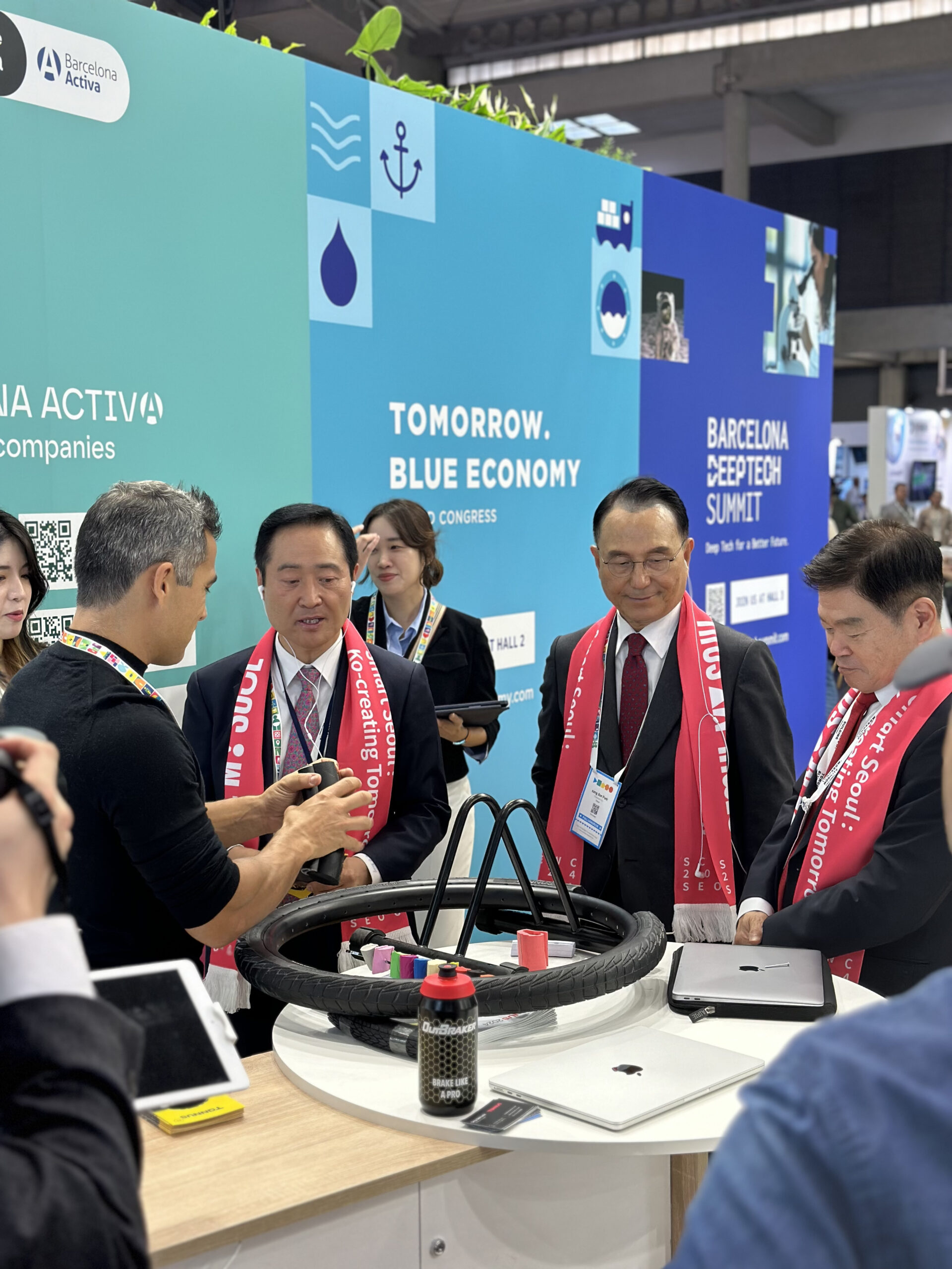 Des représentants de Séoul au stand de Tannus écoutant des explications sur les pneus solides anti-crevaison de Tannus Tires et sur la manière dont ils contribuent à la mobilité durable.