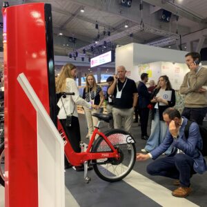 Les visiteurs de la Smart City Expo écoutent les explications sur Tannus, à côté du vélo Bicing Barcelona équipé de pneus Tannus.