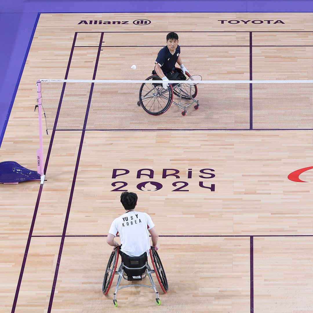 Kim Jungjun competing in badminton during a match with his wheelchair equipped with Tannus Weelchair puncture protection.